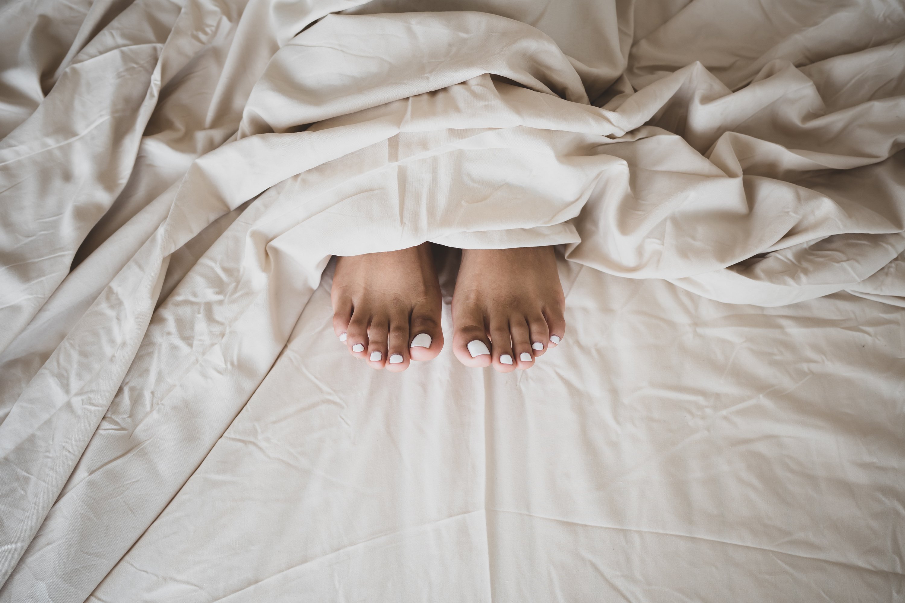 Photo of a Person's Feet with White Nail Polish